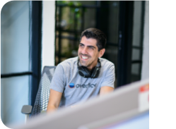 A team member with headphones around the neck, smiling for the camera.