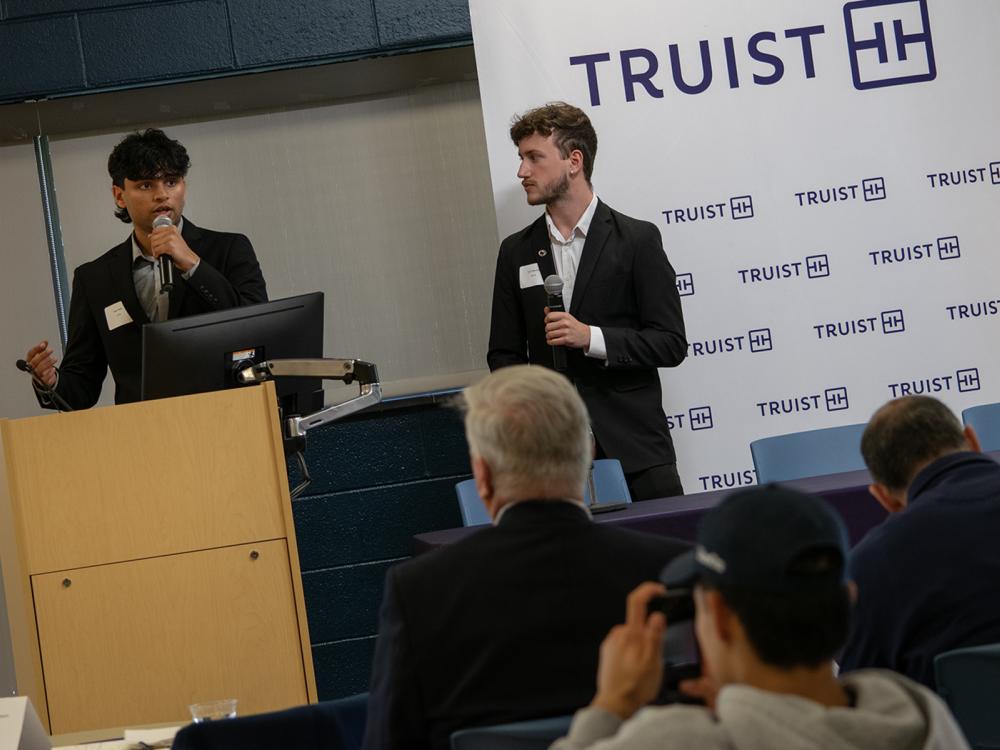 Penn State Harrisburg students Veer Patel and Tyler Muessig pitch their business idea, while standing at a lectern. 