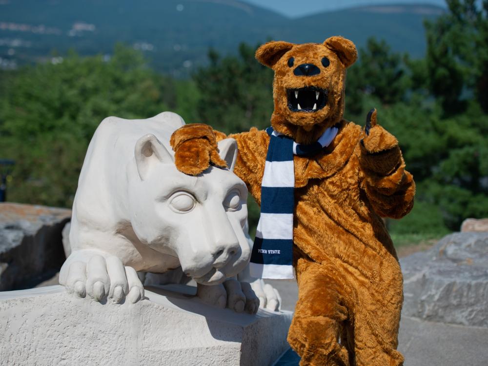 nittany lion mascot posing for photo at nittany lion shrine, pointing toward camera