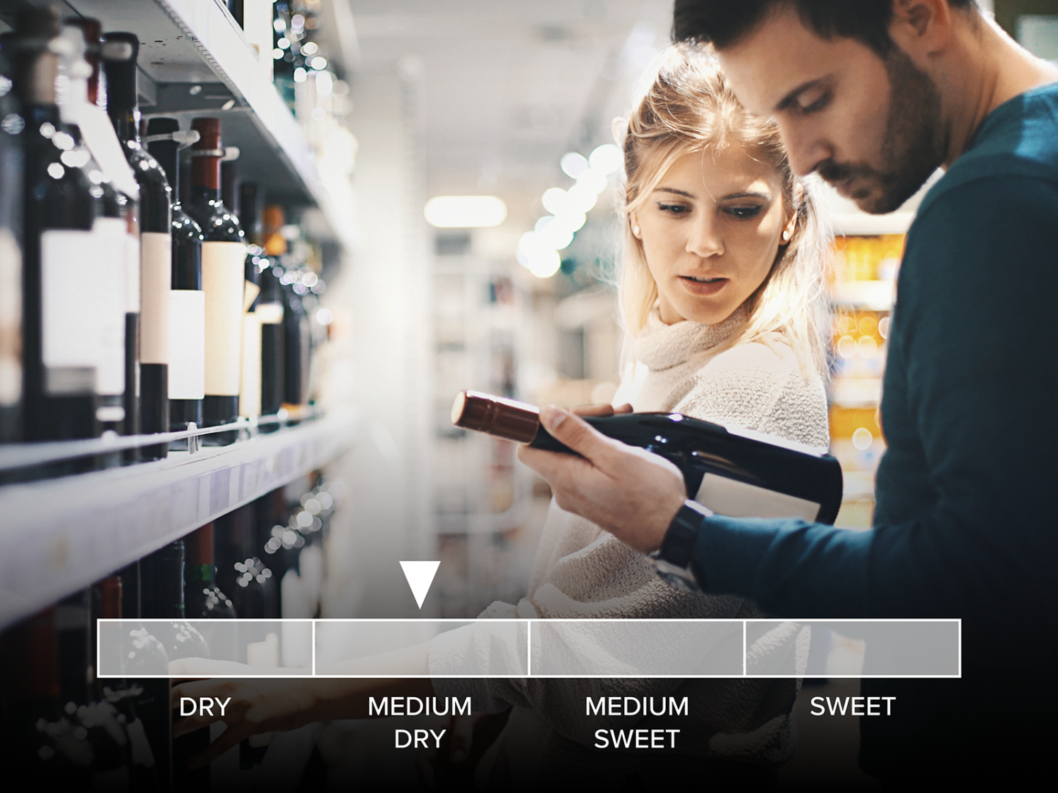 Two people looking at wine in a store