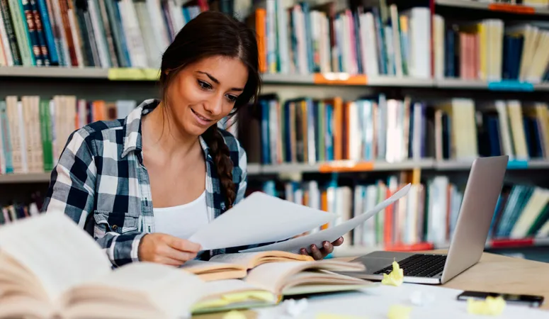 A female student using a laptop for taking study notes