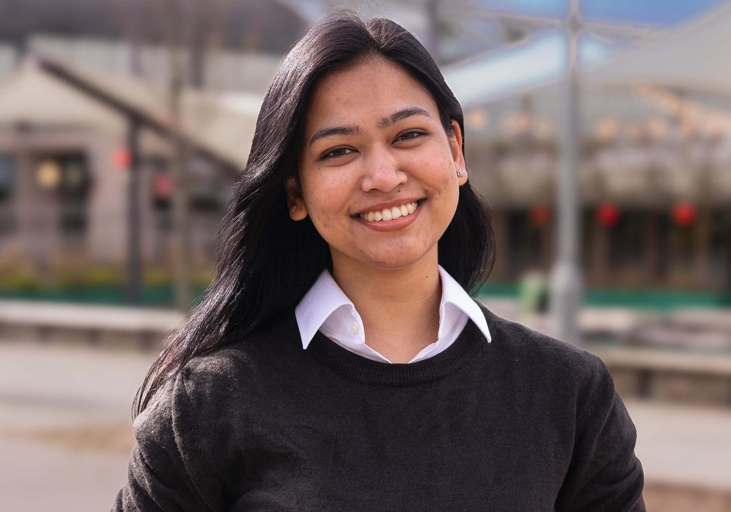 Postgraduate student in black sweater and white collared shirt.