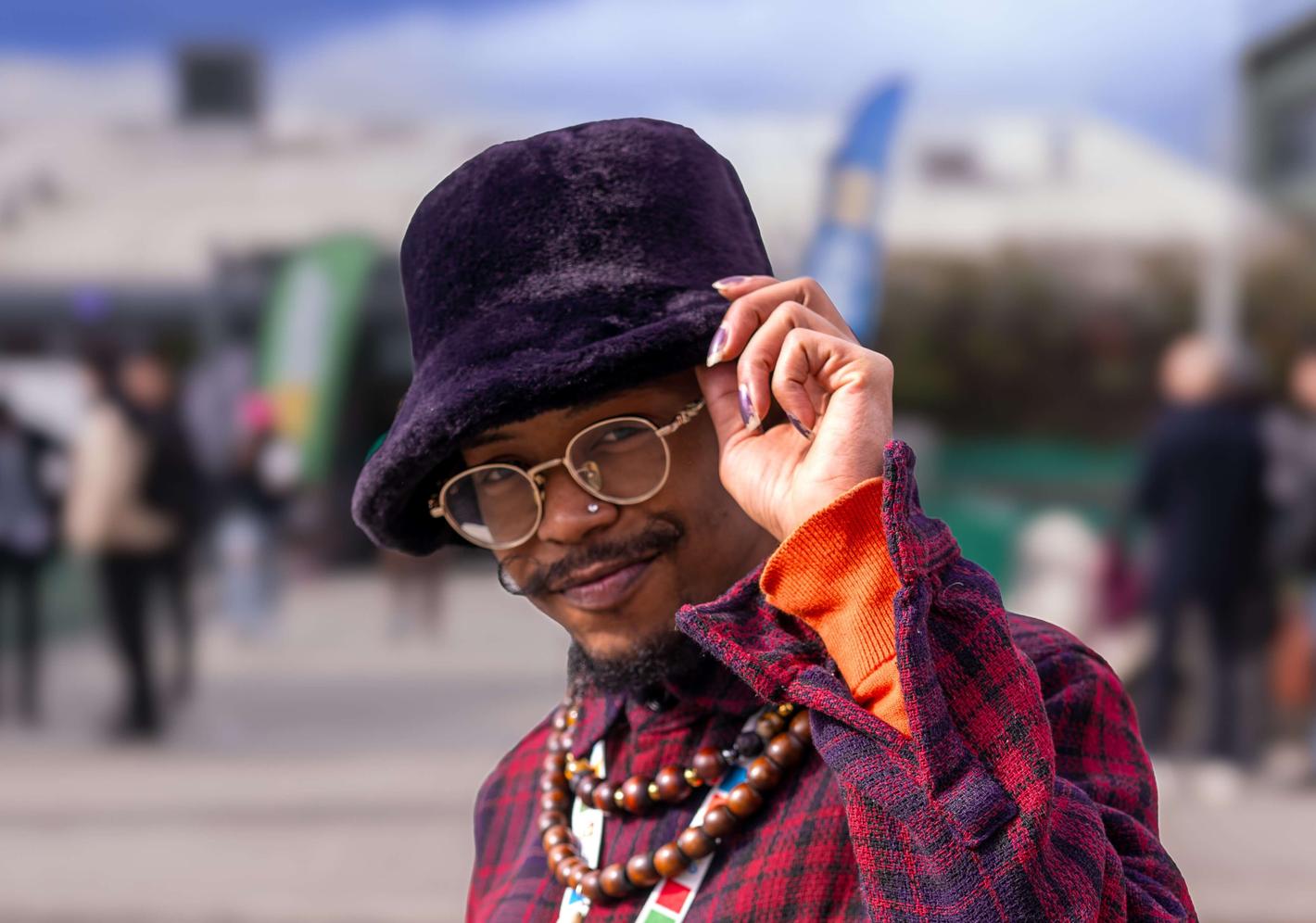 Student wearing hat and beaded necklaces