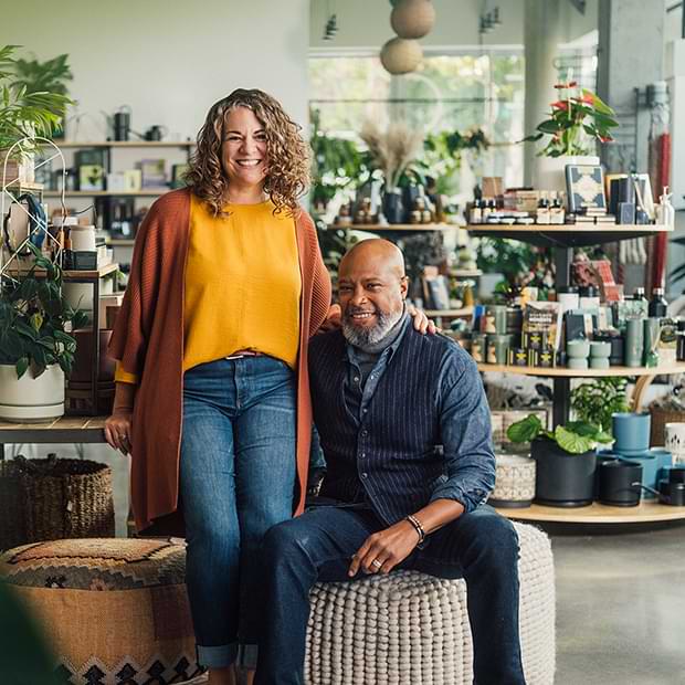 Small business co-owners happily hanging out together in their shop.