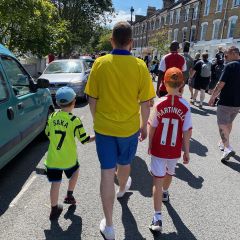 My sons and I walking along a road in Arsenal shirts