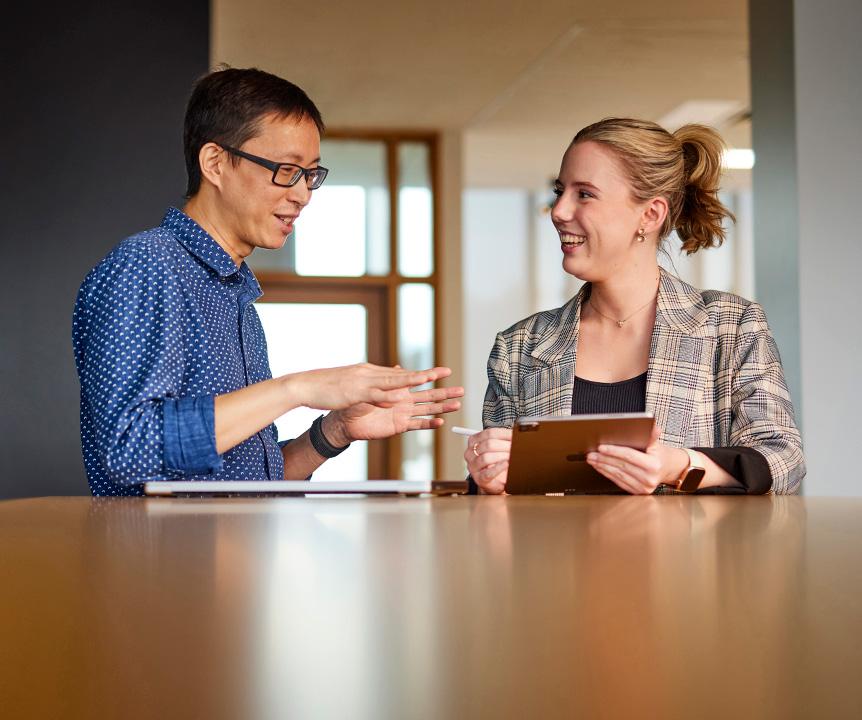 Supervisor and student talking while looking at a tablet device. 