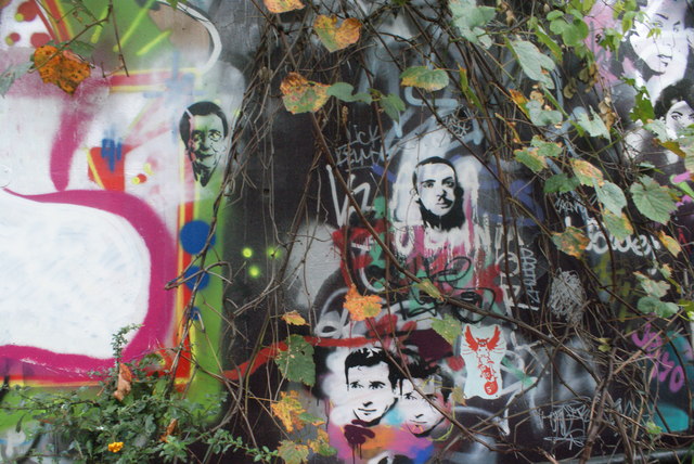 View of street art amongst the brambles at the end of Leake Street Arches