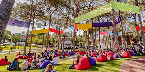 The Curtin community sitting under the pinetrees on beanbags