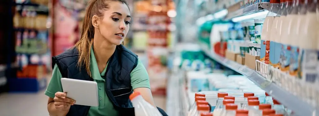 female worker using a shop floor management software on their tablet to keep track of inventory