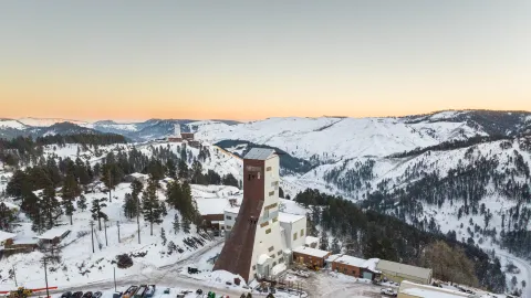 A snowy landscape view of SURF surface campus. The Ross and Yates Headframe are in view.