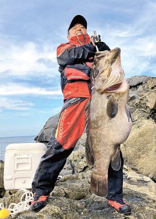 釣り上げた大物のクエを持ち上げる渡部幸太郎さん＝１６日午前、島根県海士町、二股島