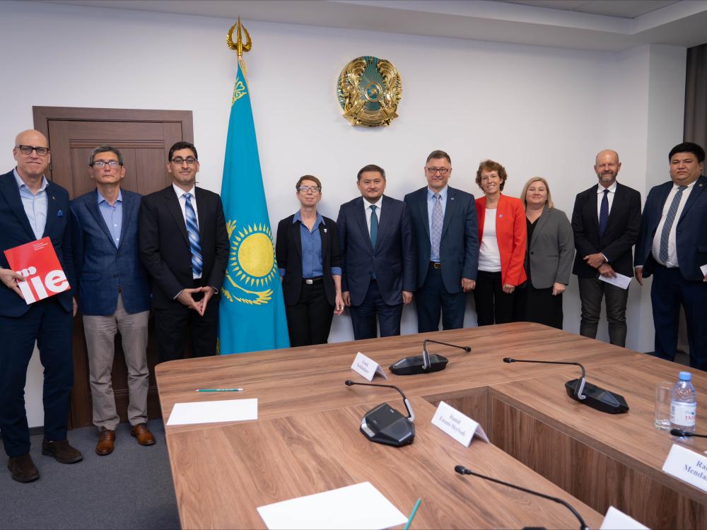 A group of people standing in a semicircle around a table