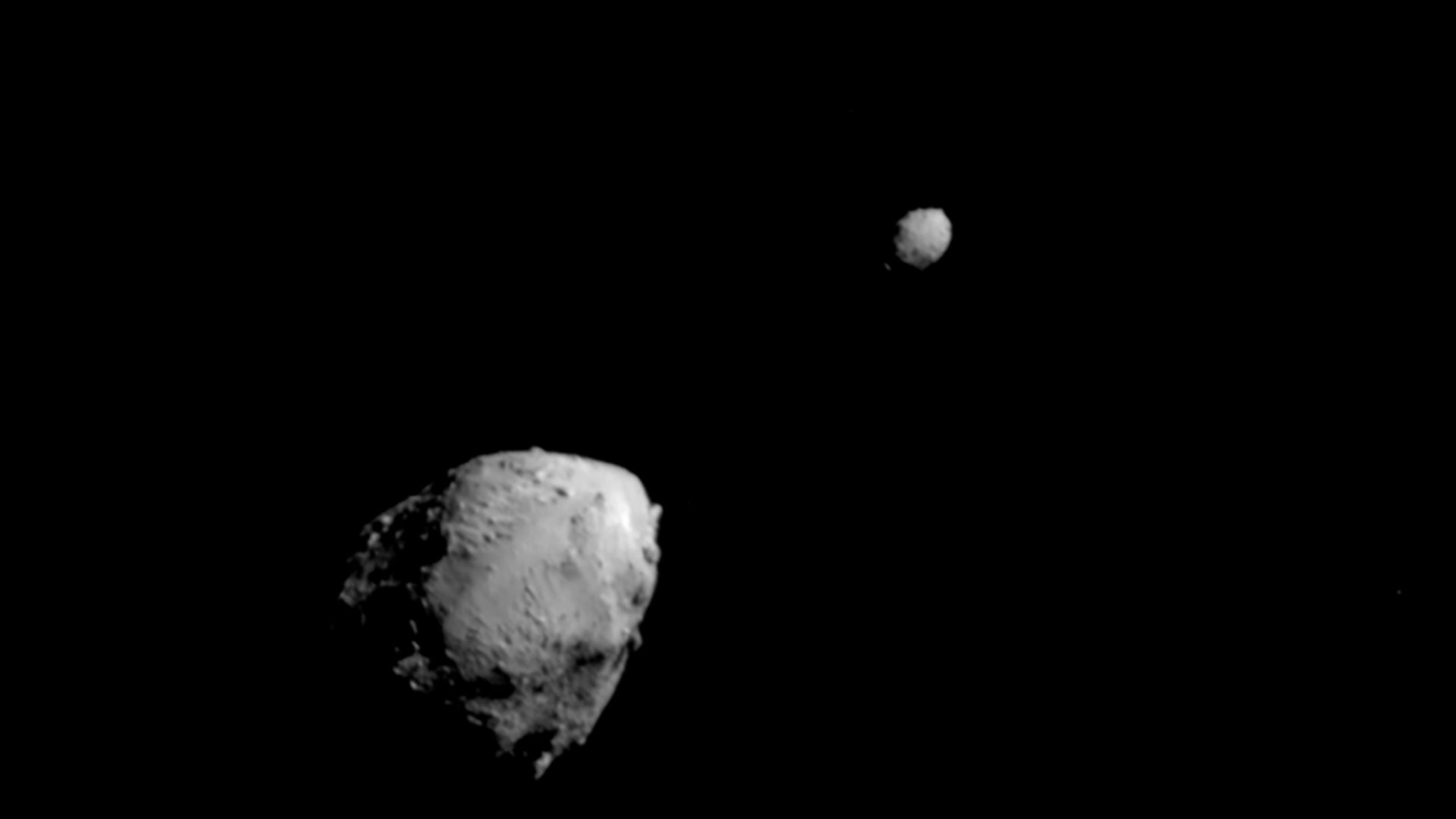 A larger asteroid on the left, and a smaller one on the right.