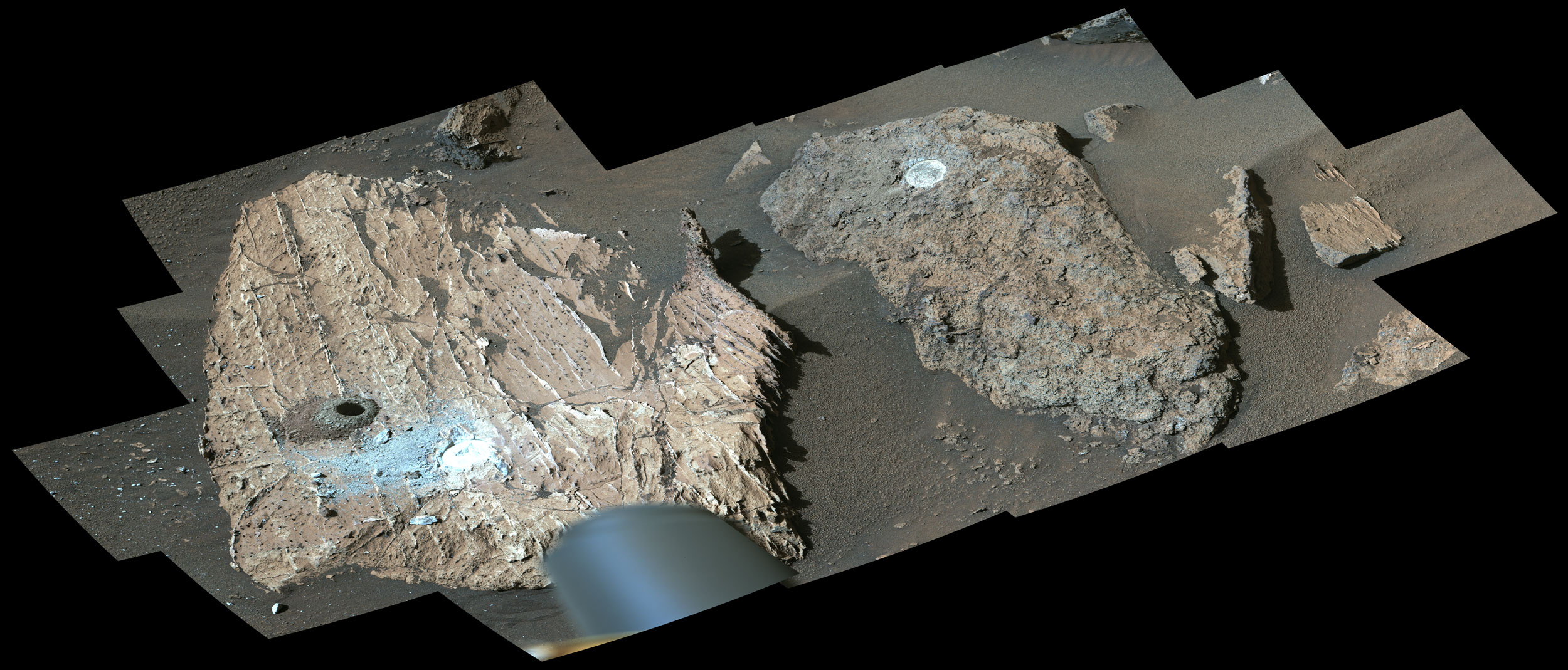 Two large rocks on the surface of Mars show have sample holes drilled in them.