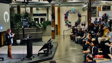 Presenter on stage speaking to SF Python members at the GitHub Community Space