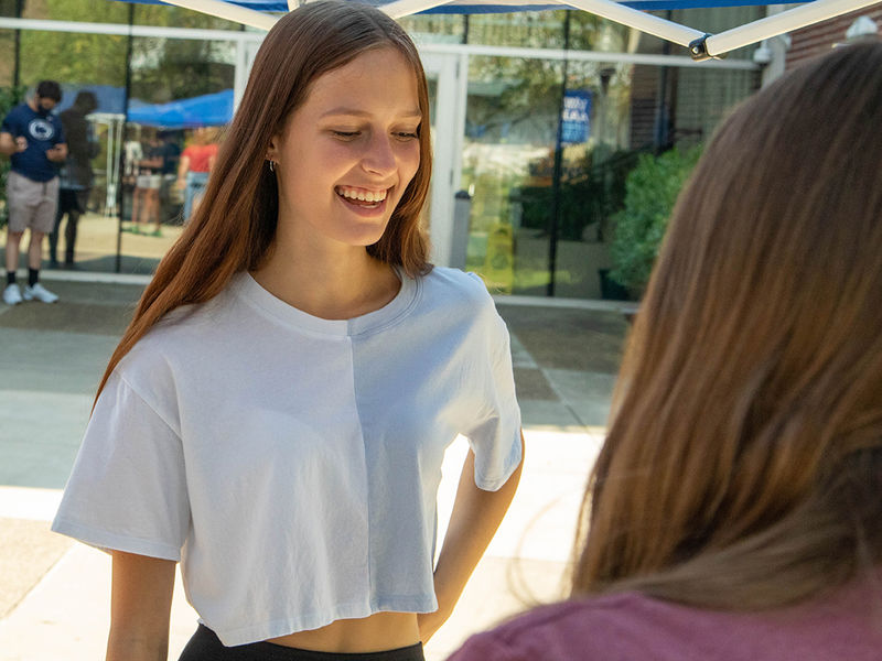 Student talking to staff at outdoor event