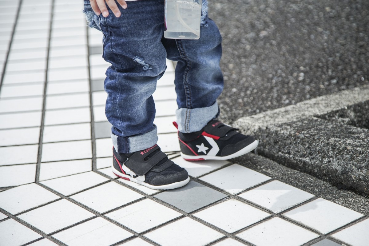 A young boy riding a skateboard down a sidewalk