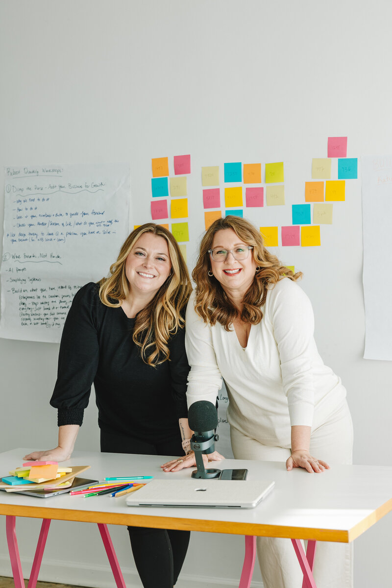 melissa and corry standing at desk smiling at camera