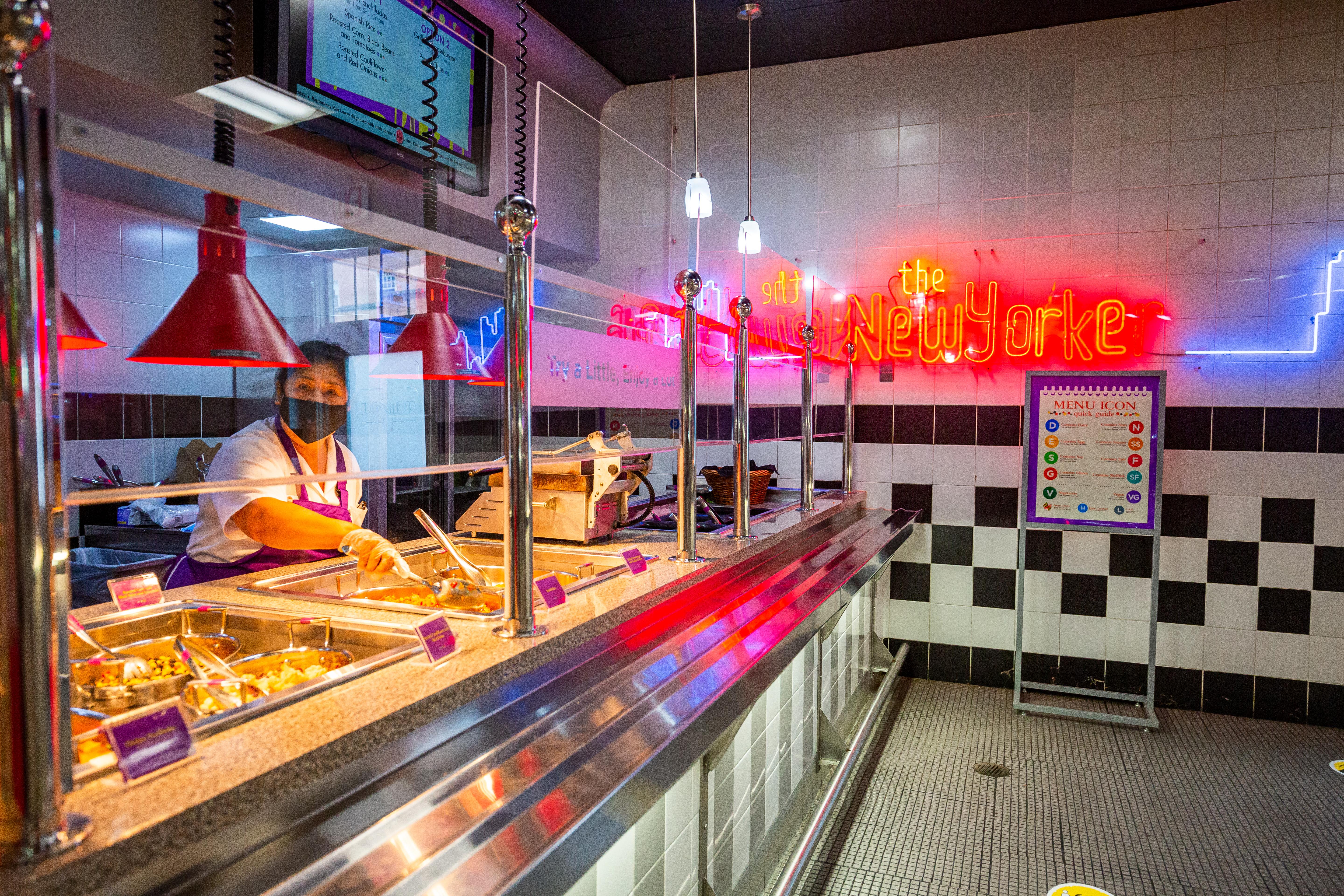 Female worker at The Diner behind glass partition