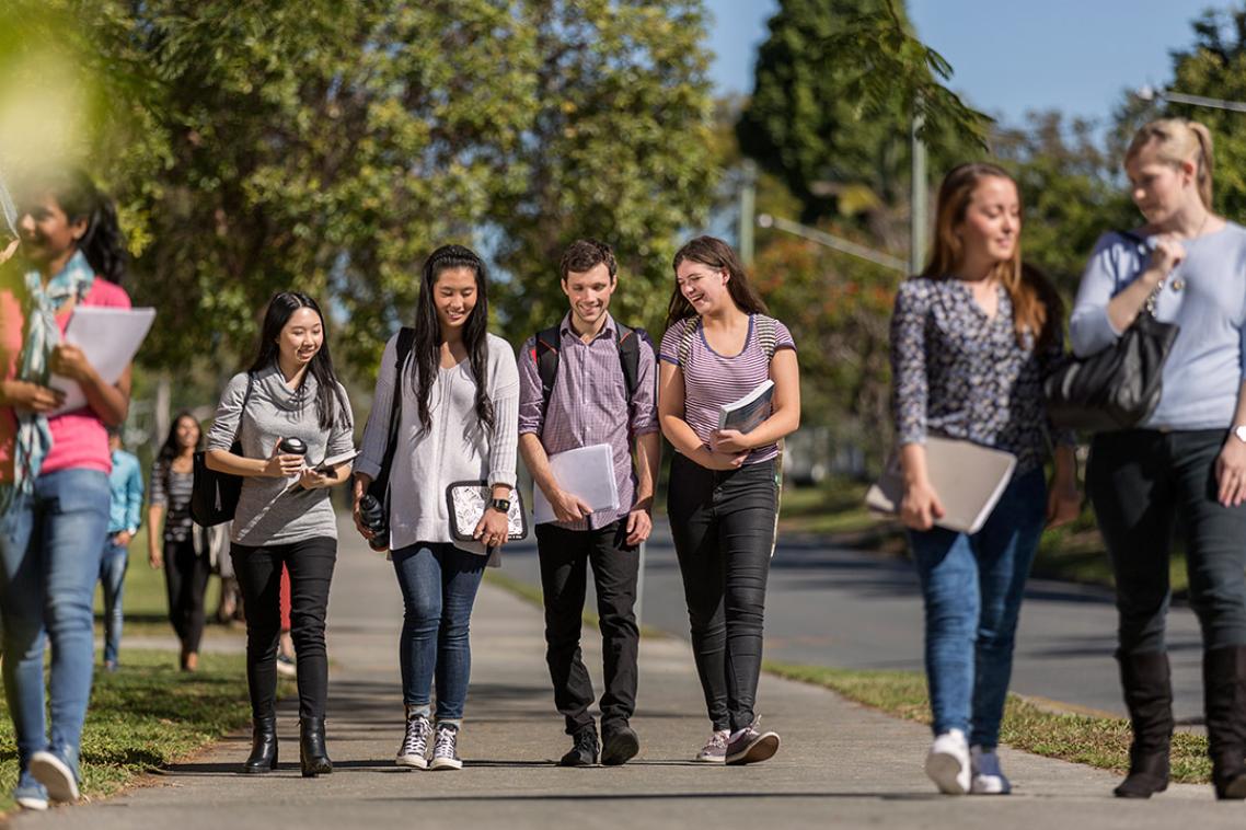 Group of happy students walking to class together