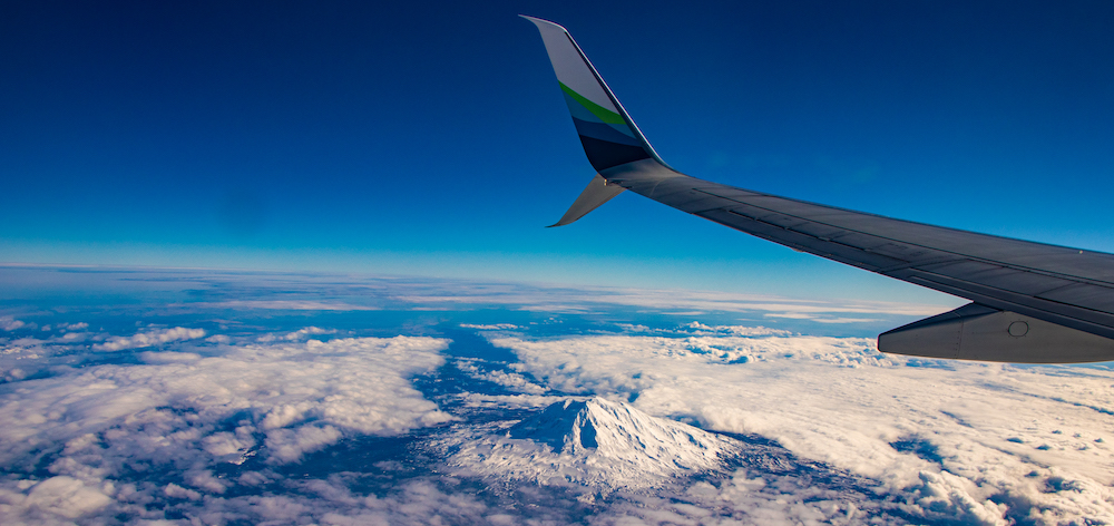 view of Mt. Rainier from airplane, with plane wing visible