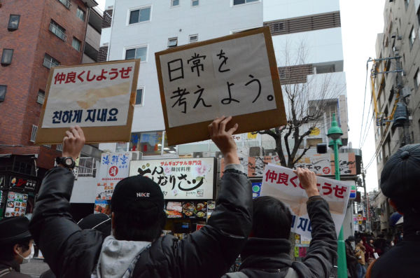 「民族差別はやめよう」とカウンターに駆け付けた有志たちは、「仲良くしようぜ」のプラカードを掲げた。＝写真：諏訪撮影＝