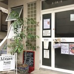 Vegan Sousaku Katei Ryouri KLASINA - 玄関口。KLASINAの看板と表の植物が目印です。夜の定食会スケジュールは柱にかけてある黒板を参照ください。