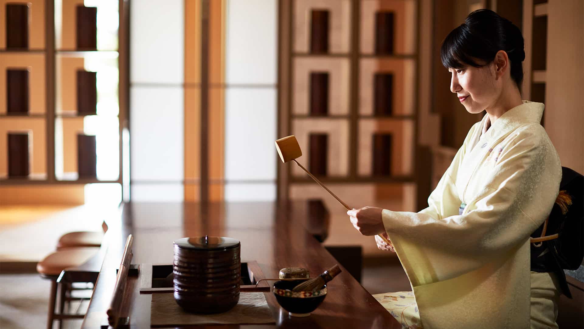 woman brewing tea in traditional kyoto tea ceremony