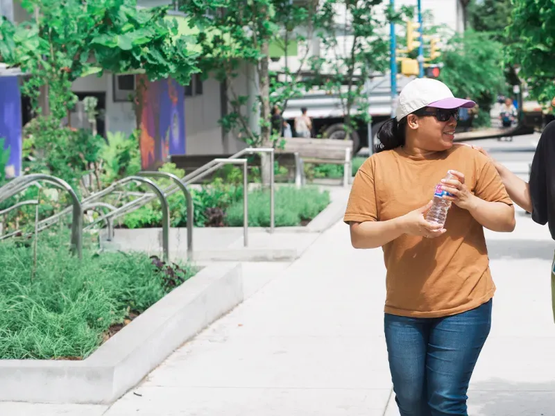 UGM employee sharing cold beverage with community member