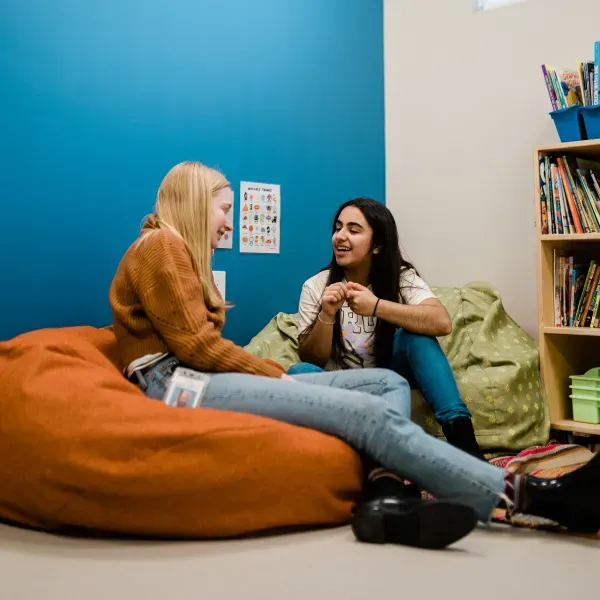 UGM staff chatting to Eastsider program graduate on bean bags