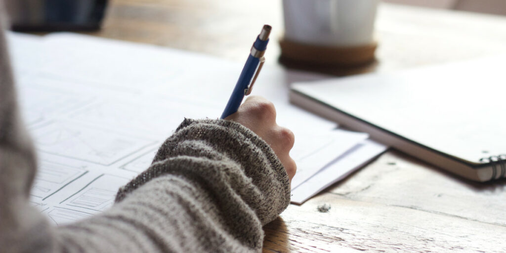 A person writing at a desk.