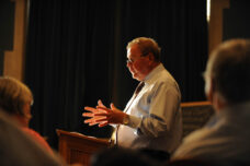 A law school professor  is lit by the afternoon sun as he instructs an international law workshop in Hutchins Hall.