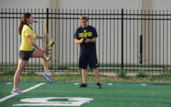 A marching band saxophonist works on precision marching with the help of a fellow bandmate at Elbel Field.