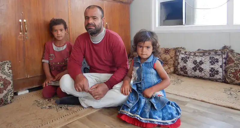 Former park squatter Suliman Hassan Matar and two of his children in their new home in Mosul, Iraq provided under an EU funded rehabilitation project run by UN-Habitat