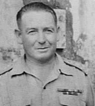 A black and white head and shoulders photograph of a middle-aged man in uniform