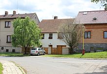 Řada zděných patrových domů (uprostřed nich dům čp. 81, před nímž stojí automobil Škoda Fabia).