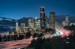 Cityscape of a busy major city backlit by an evening sky during sunset.