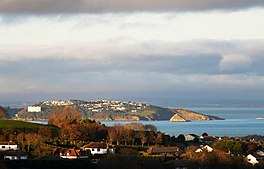 A view across a bay with inlets and many houses on the cliffs