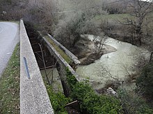 Pont de pierre, large de 50 cm, à parapets, en partie effondré.