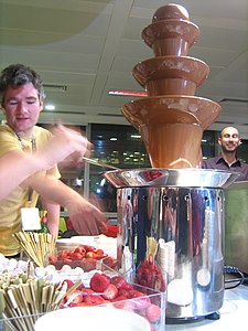 Various foods dipped into a chocolate fountain