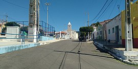 Rua Padre Tertuliano Fernandes, no centro da cidade. Ao fundo a capela de Santa Luzia, padroeira do município.