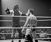 Kane, Daniel Bryan'a kendisine sarılması için kollarını uzatırken.