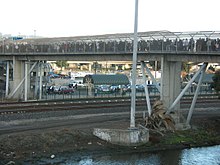 A concrete footbridge over railway tracks
