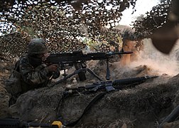 US Navy Seabees completed defensive machine gun position during training with camouflage netting and timber supports, 2010.