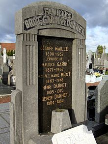 Photographie d'un monument funéraire en pierre grise et marbre noir.