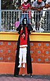 Girl with skeleton figure on stilts at Day of the Dead festivities