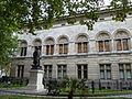 National Portrait Gallery, London, 1890–95 by Ewan Christian, north front towards Charing Cross Road with the statue of Sir Henry Irving (1908–10 by Sir Thomas Brock) set before it[152]