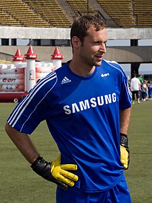 A image of Petr Čech on the field, wearing blue clothes with a sponsorship from a brand