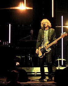 Mills singing and playing bass guitar with Stringfellow behind him on keyboards