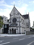 Photographie en couleurs de la façade d'une chapelle précédée d'un petit porche.